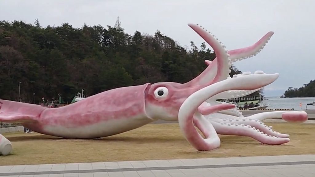A rather large squid statue. Its tentacles are all over the place and it's giant eye is looking up at the sky.